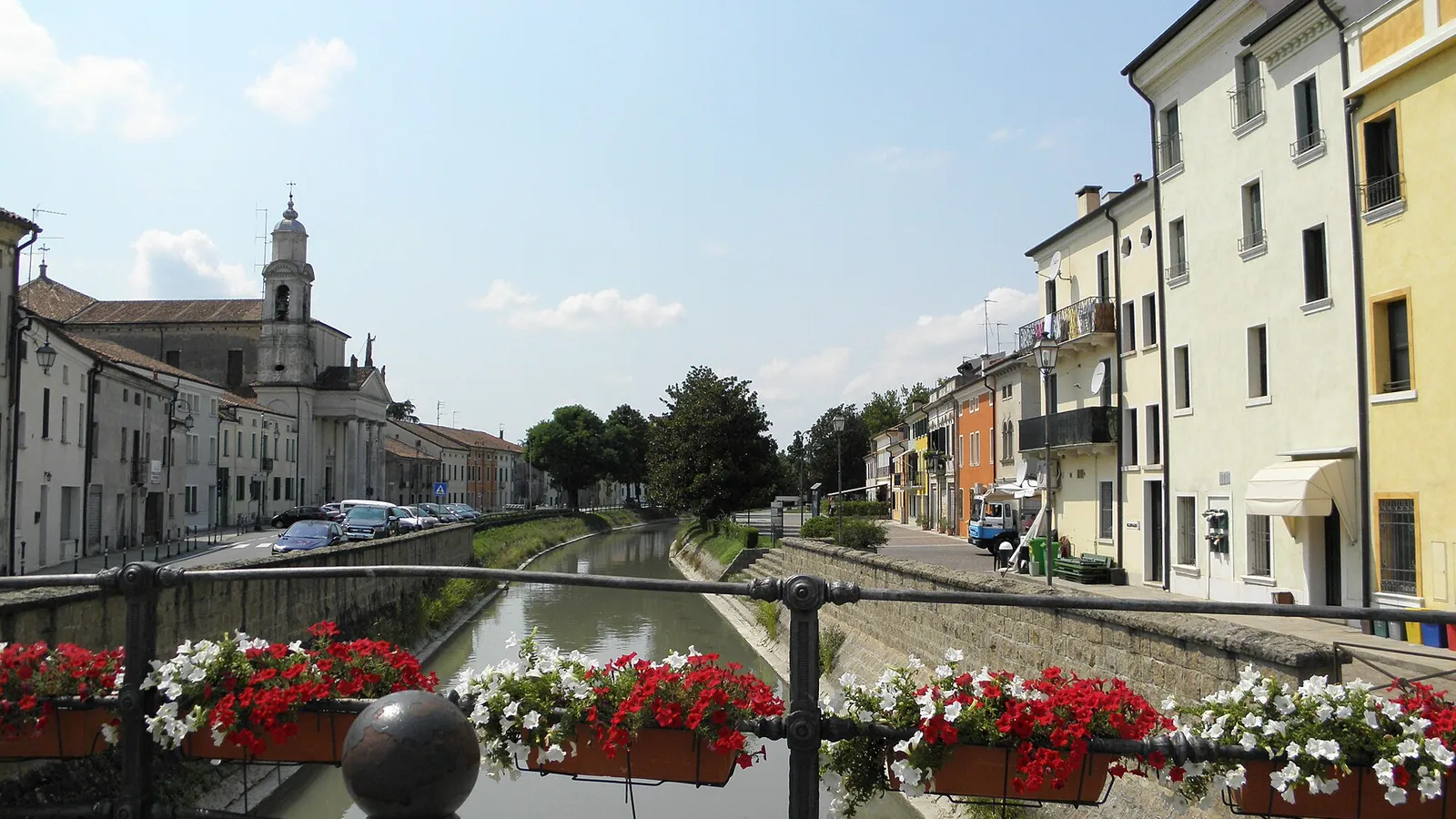 Il canale Adigetto a Lendinara con case colorate e fioriere lungo il ponte