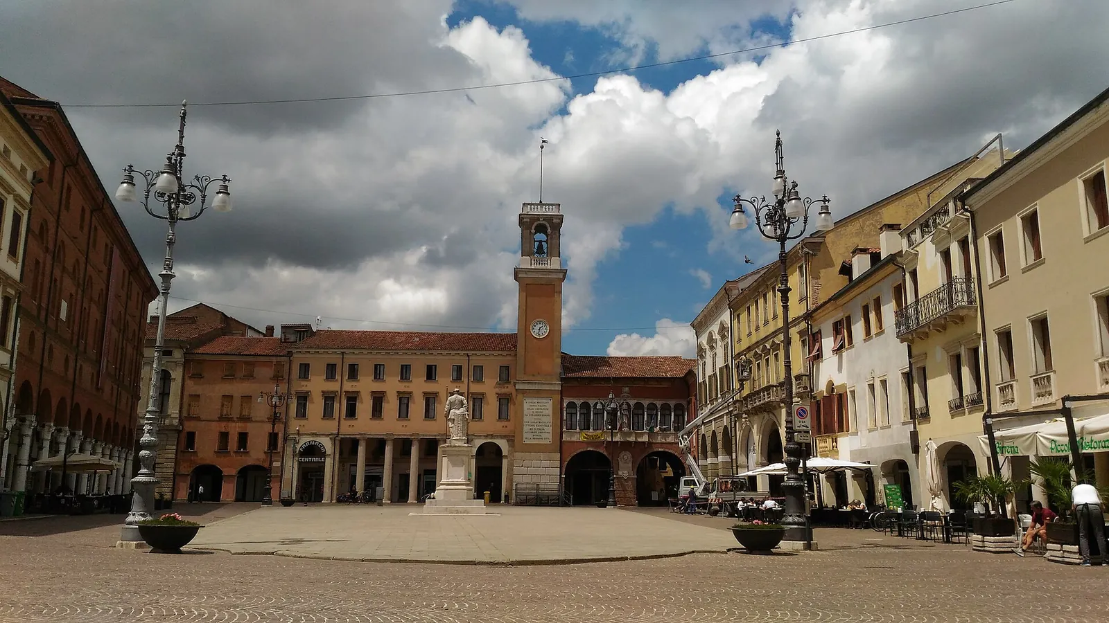 Piazza Vittorio Emanuele II a Rovigo con la torre dell'orologio, sotto un cielo nuvoloso