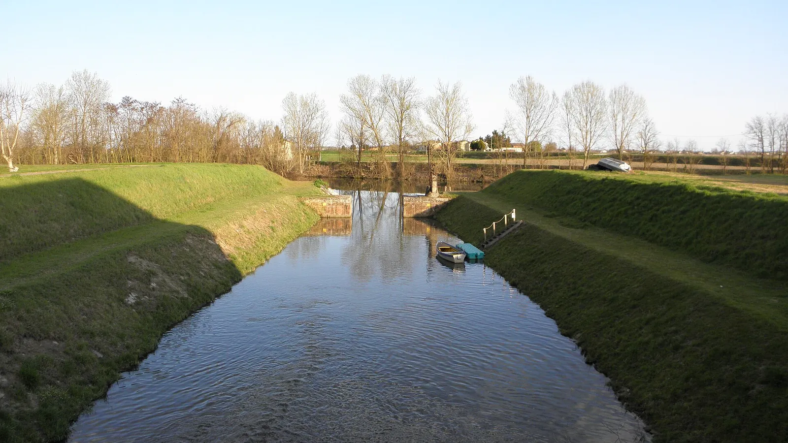 Un canale con sponde erbose che si getta nel Canalbianco a Fratta Polesine
