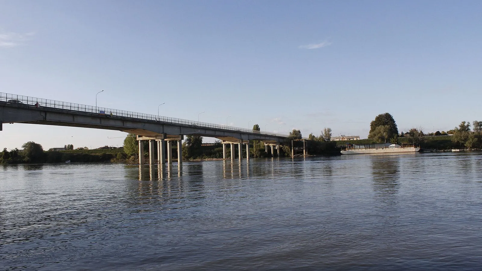 Il ponte stradale sul Po a Polesella, poggiato su alti piloni, visto dalla riva